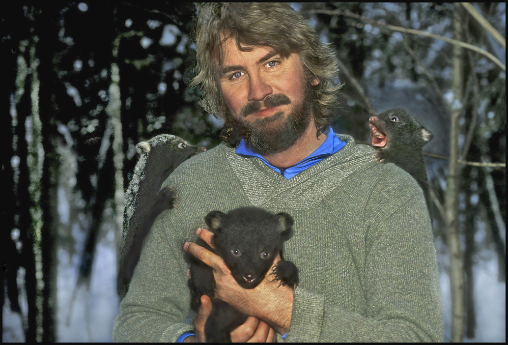 Portrait of National Geographic photographer Raymond Gehman holding three bear cubs