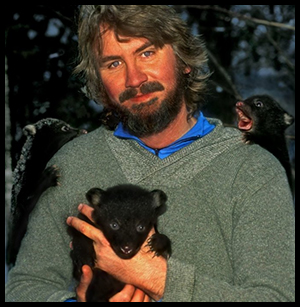 Portrait of photographer Raymond Gehman with three bear cubs on him