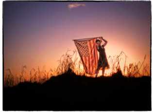 A woman holding an American flag at sunset on Dinner Island Ranch, Florida